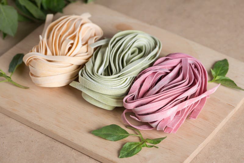 3 части красочных сырцовых итальянских макаронных изделий fettuccine с базиликом стоковая фотография rf 3 части красочных сырцовых итальянских макаронных изделий fettuccine с базиликом стоковая фотография rf