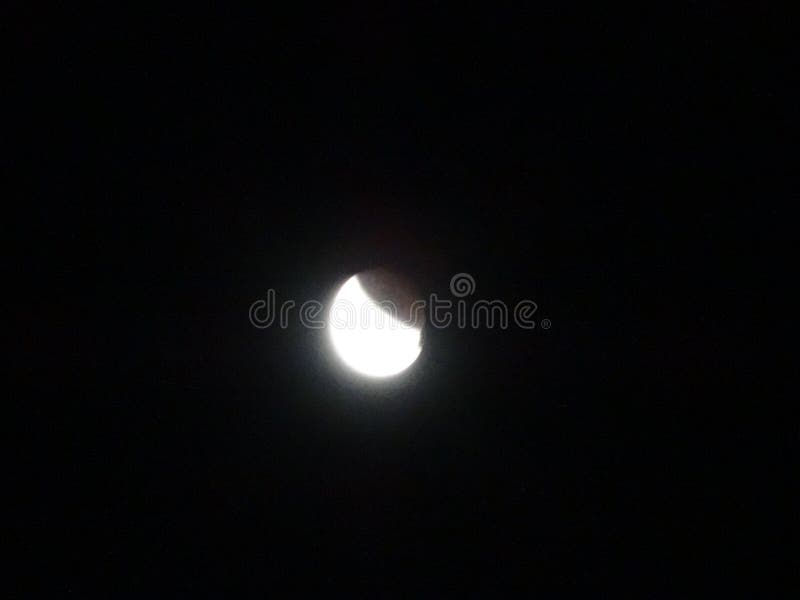 частичное лунное затмение в ночном небе стоковая фотография