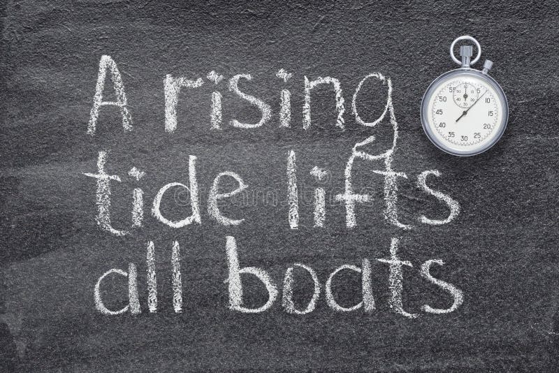 A rising tide lifts all boats proverb written on chalkboard with vintage precise stopwatch. A rising tide lifts all boats proverb written on chalkboard with vintage precise stopwatch