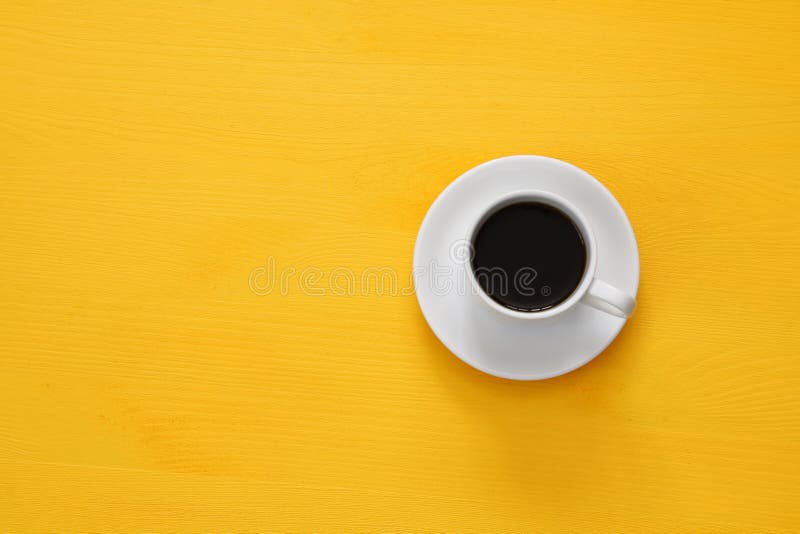 чашка coffe на деревянной желтой предпосылке стоковые фото