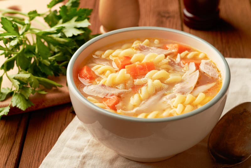 Bowl of chicken noodle soup on a wooden table. Bowl of chicken noodle soup on a wooden table.