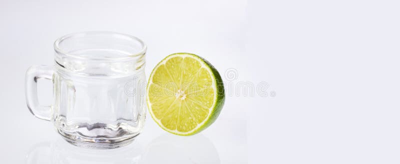 Чашка теплой воды с лимоном- белым фоном