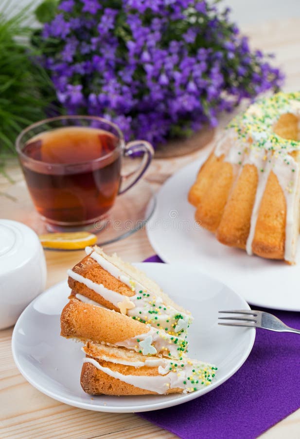 Чашка чаю и торт на tableware фарфора на фиолетовой скатерти стоковое фото rf Чашка чаю и торт на tableware фарфора на фиолетовой скатерти стоковое фото rf