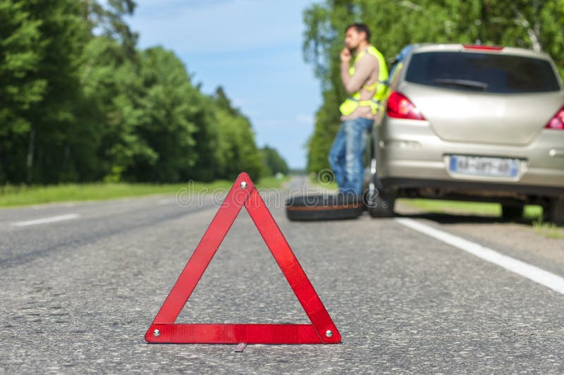 Человек в отражательном жилете вызывая к помощи автомобиля после breakdo стоковое фото Человек в отражательном жилете вызывая к помощи автомобиля после breakdo стоковое фото