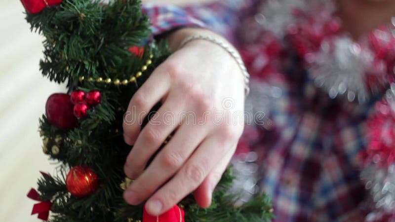 Человек одевает красивую маленькую накаляя рождественскую елку