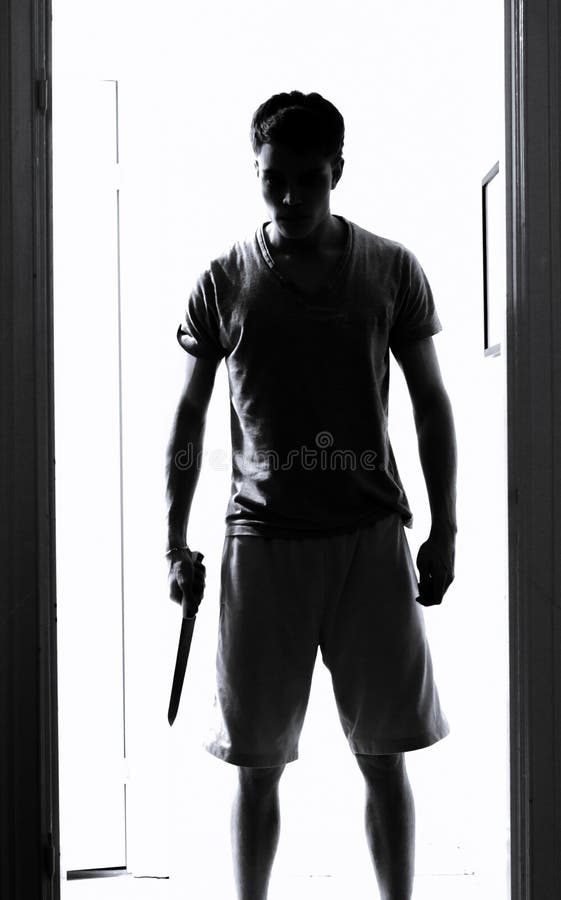 Man with a knife standing in doorway staring. Man with a knife standing in doorway staring