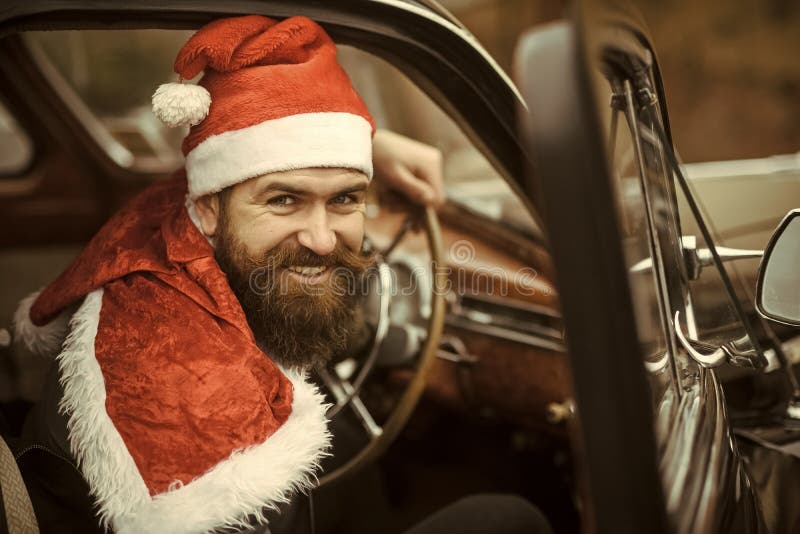 Человек в улыбке шляпы santa в ретро автомобиле стоковые фотографии rf Человек в улыбке шляпы santa в ретро автомобиле стоковые фотографии rf