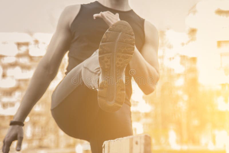 Человек в черных одеждах работает outdoors с барьером спортсмен фитнеса на спортивной площадке тренировка с барьером E стоковая фотография rf Человек в черных одеждах работает outdoors с барьером спортсмен фитнеса на спортивной площадке тренировка с барьером E стоковая фотография rf