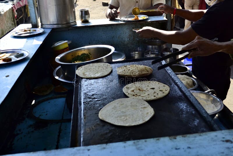 Человек делая chapati Индийский стойл еды улицы стоковое изображение rf Человек делая chapati Индийский стойл еды улицы стоковое изображение rf