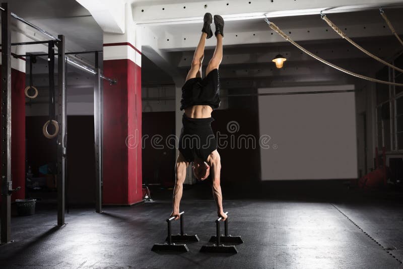 Человек делая Handstand на параллельном баре стоковая фотография Человек делая Handstand на параллельном баре стоковая фотография