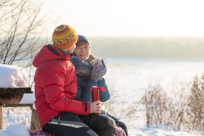 Человек и женщина бросают вверх снег и иметь потеху outdoors с целью реки Морозный солнечный зимний день стоковое фото Человек и женщина бросают вверх снег и иметь потеху outdoors с целью реки Морозный солнечный зимний день стоковое фото