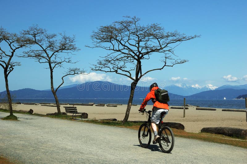 Man bicycling on beach, winter scene. Man bicycling on beach, winter scene