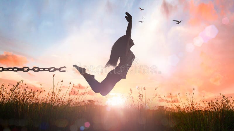 Silhouette of a girl jumping and broken chains at sunset meadow with her hands raised. Silhouette of a girl jumping and broken chains at sunset meadow with her hands raised.