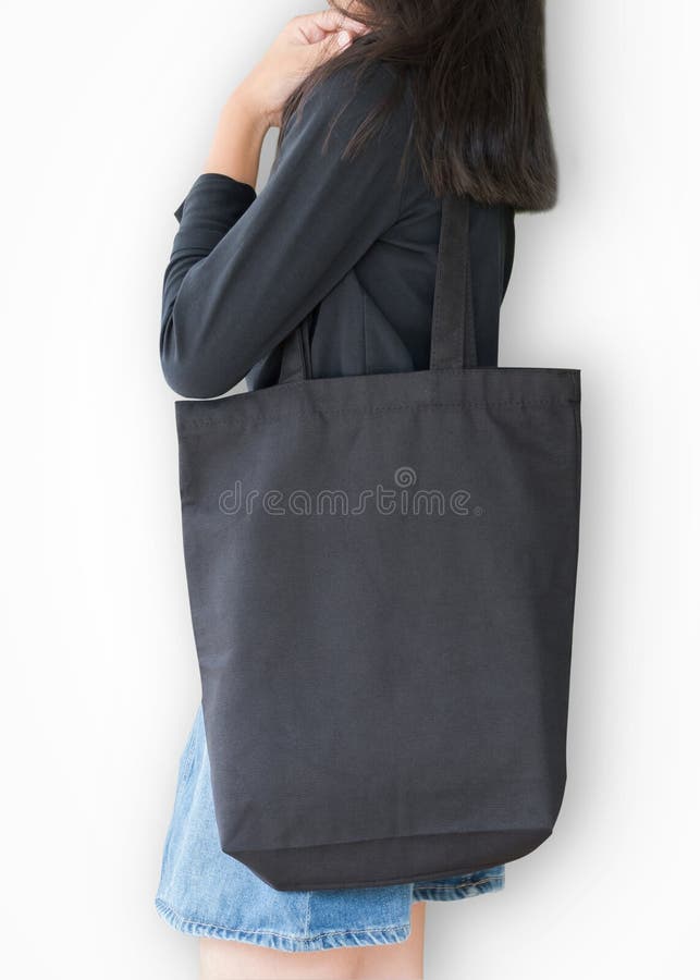Черная текстура тканей холста хлопка шаблона модель-макета сумки tote по плечу девушки изолированном с путем вырезки на белом фоне стоковая фотография