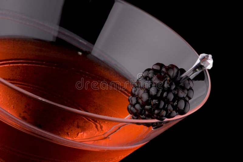 Martini in chilled glass over black background on reflection surface. Red color, made with blackberry liqueur and garnished with freah blackberry. Most popular cocktails series. Martini in chilled glass over black background on reflection surface. Red color, made with blackberry liqueur and garnished with freah blackberry. Most popular cocktails series.