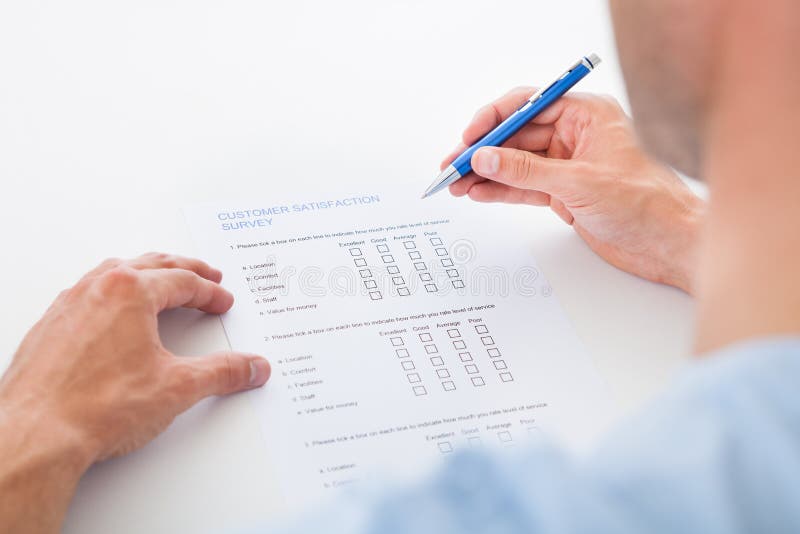 Close-up Of A Person Filling Survey Form With Pen. Close-up Of A Person Filling Survey Form With Pen