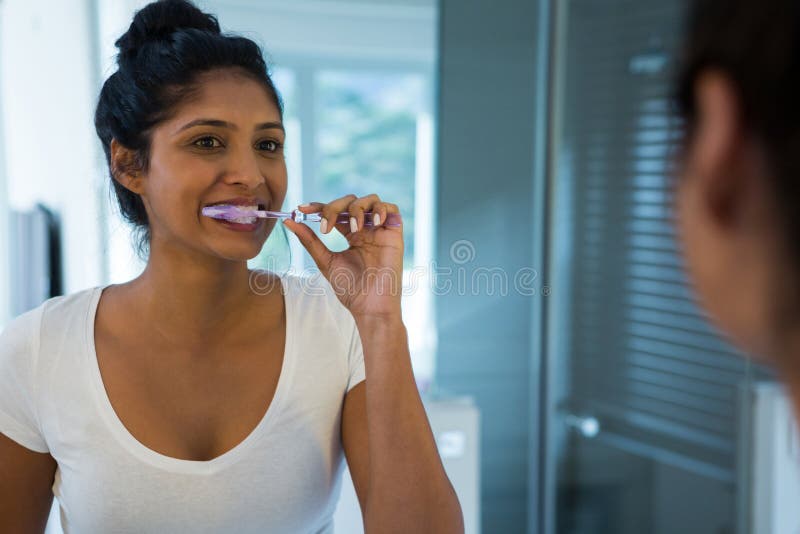 Woman brushing teeth in bathroom. Woman brushing teeth in bathroom