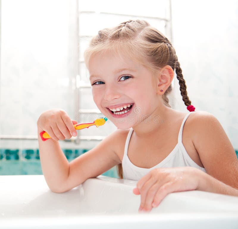 Little girl brushing teeth in bath. Little girl brushing teeth in bath