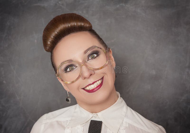 Crazy smiling woman in the eyeglasses on the blackboard background. Crazy smiling woman in the eyeglasses on the blackboard background