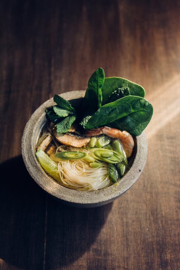 Concrete Bowl of Asian Noodle Soup with chopsticks, on wood table, from above. Concrete Bowl of Asian Noodle Soup with chopsticks, on wood table, from above