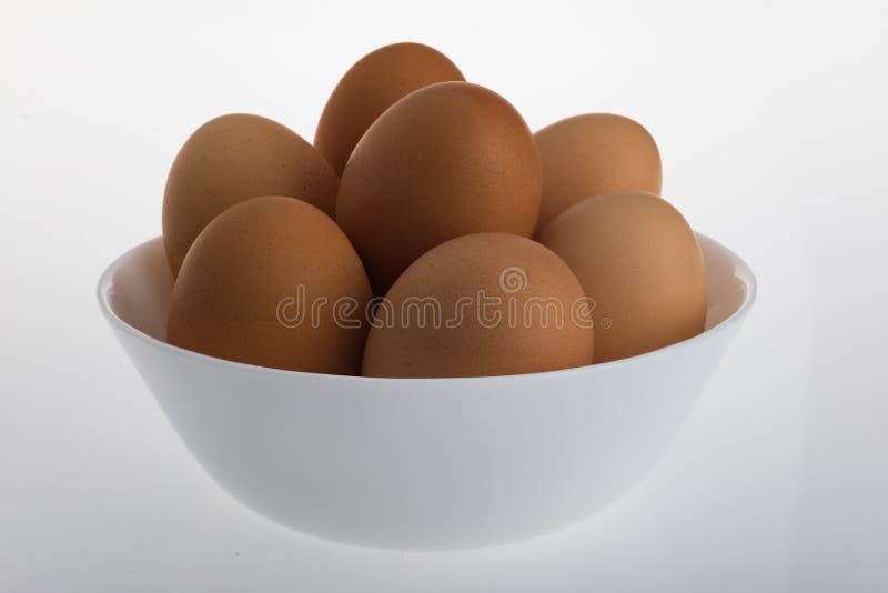 An Arrangement of eggs in a white bowl with a white background. An Arrangement of eggs in a white bowl with a white background