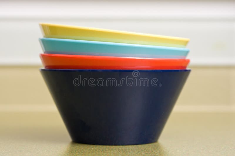 Four brightly colored bowls stacked on kitchen counter. Four brightly colored bowls stacked on kitchen counter