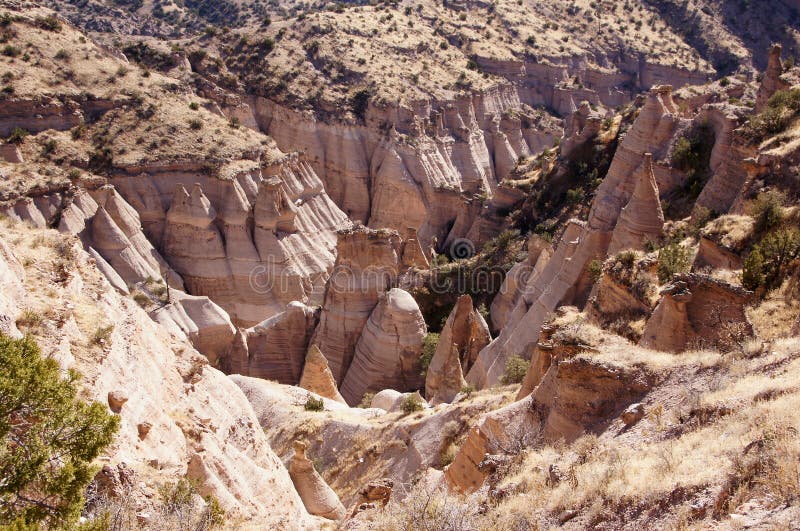 Kasha-Katuwe Tent Rocks National Monument, located 40 miles southwest of Santa Fe, New Mexico (near Cochiti), is a Bureau of Land Management (BLM) managed site that was established as a U.S. National Monument by President Bill Clinton in January 2001 shortly before leaving office. Kasha-Katuwe means white cliffs in the Pueblo language Keresan. The area owes its remarkable geology to layers of volcanic rock and ash deposited by pyroclastic flow from a volcanic explosion within the Jemez Volcanic Field that occurred 6 to 7 million years ago. Over time, weathering and erosion of these layers has created canyons and tent rocks. The tent rocks themselves are cones of soft pumice and tuff beneath harder caprocks, and vary in height from a few feet to 90 feet. The monument is open for day use only and may be closed by order of the Cochiti Pueblo Tribal Governor. A 1.2 mile (1.9 km) recreation trail leads up through a slot canyon to a lookout point where the tent rocks may be viewed from above. A 1.3 mile (2 km) loop trail leads past their base. The park is located on the Pajarito Plateau between 5700 and 6400 feet (1737–1951 m) above sea level. Kasha-Katuwe Tent Rocks National Monument, located 40 miles southwest of Santa Fe, New Mexico (near Cochiti), is a Bureau of Land Management (BLM) managed site that was established as a U.S. National Monument by President Bill Clinton in January 2001 shortly before leaving office. Kasha-Katuwe means white cliffs in the Pueblo language Keresan. The area owes its remarkable geology to layers of volcanic rock and ash deposited by pyroclastic flow from a volcanic explosion within the Jemez Volcanic Field that occurred 6 to 7 million years ago. Over time, weathering and erosion of these layers has created canyons and tent rocks. The tent rocks themselves are cones of soft pumice and tuff beneath harder caprocks, and vary in height from a few feet to 90 feet. The monument is open for day use only and may be closed by order of the Cochiti Pueblo Tribal Governor. A 1.2 mile (1.9 km) recreation trail leads up through a slot canyon to a lookout point where the tent rocks may be viewed from above. A 1.3 mile (2 km) loop trail leads past their base. The park is located on the Pajarito Plateau between 5700 and 6400 feet (1737–1951 m) above sea level.