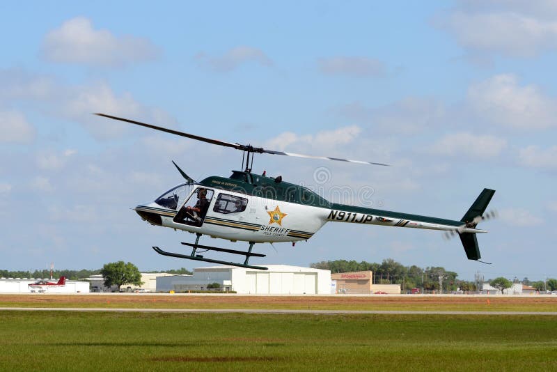 Lakeland, USA - April 1, 2012: Polk County, Florida Sheriff department helicopter Bell OH-58A departing on a patrol in early morning. Polk County is a rural area west of Orlando, Florida. Lakeland, USA - April 1, 2012: Polk County, Florida Sheriff department helicopter Bell OH-58A departing on a patrol in early morning. Polk County is a rural area west of Orlando, Florida