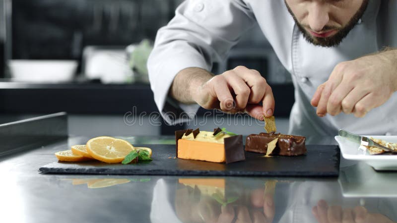 Шеф-повар варя торт на рабочем месте Руки крупного плана мужские уточняя десерт