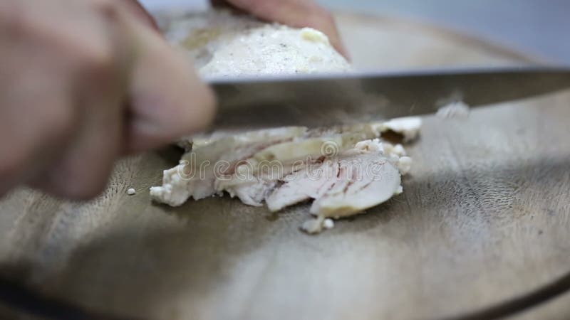 Шеф-повар режет кипеть филе цыпленка на деревянной доске