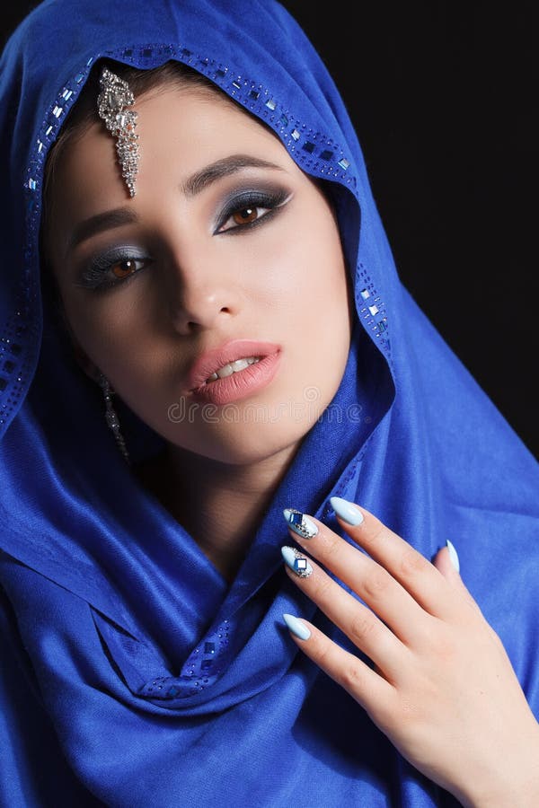 Шикарный молодой восточный портрет стороны женщины в hijab Девушка с яркими бровями, совершенный состав красоты модельная, касаяс стоковое фото rf Шикарный молодой восточный портрет стороны женщины в hijab Девушка с яркими бровями, совершенный состав красоты модельная, касаяс стоковое фото rf
