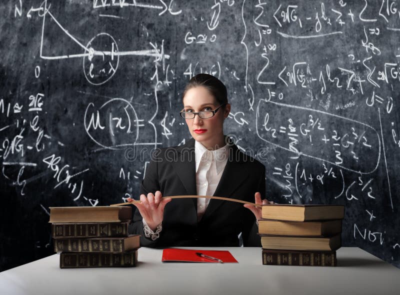 Portrait of a school teacher sitting in front of a blackboard. Portrait of a school teacher sitting in front of a blackboard