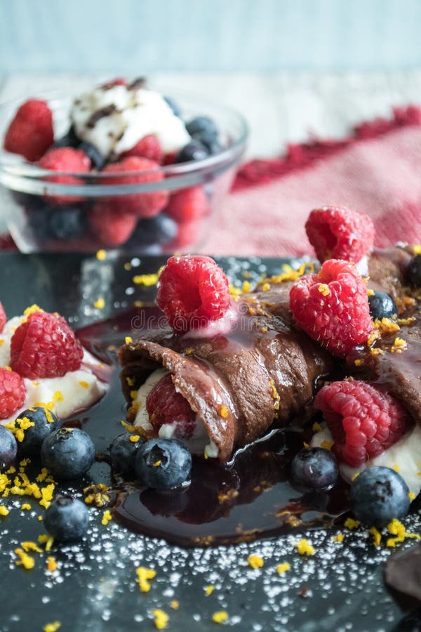 Шоколад Crepes заполненное с сыром рикотты и покрыл с голубикой, поленико стоковые изображения Шоколад Crepes заполненное с сыром рикотты и покрыл с голубикой, поленико стоковые изображения