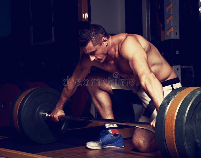 Штанга красивого сильного зверского человека поднимаясь в спортзале crossfit на da стоковые фото Штанга красивого сильного зверского человека поднимаясь в спортзале crossfit на da стоковые фото