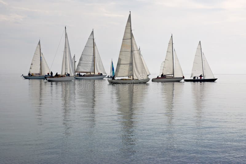 Many sailboats as seen from beach in pacific northwest, calm glassy water, puget sound. Many sailboats as seen from beach in pacific northwest, calm glassy water, puget sound