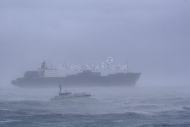 A large cargo ship leaves the harbor at Flushing &#x28;Vlissingen&#x29;, the Netherlands in a heavy storm. A large cargo ship leaves the harbor at Flushing &#x28;Vlissingen&#x29;, the Netherlands in a heavy storm.