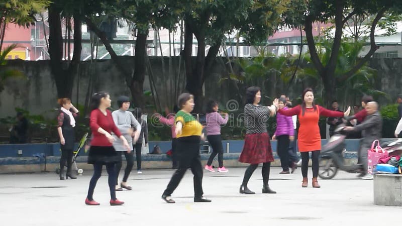 Шэньчжэнь, Китай: женщины танцующ и занимательны
