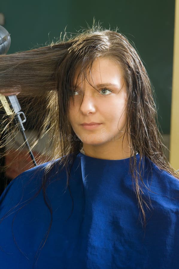 Nice girl in a beauty salon while an hair stylist brush and dry her hair. Nice girl in a beauty salon while an hair stylist brush and dry her hair