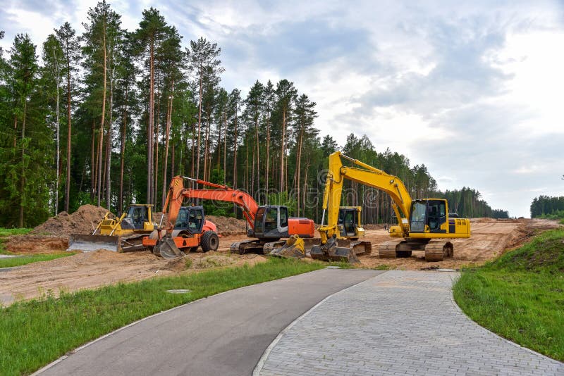 Экскаватор бульдозера и compactor почвы на дорожной работе. Тяжелые earthmoving строительная техника и оборудование в ходе земли стоковые фотографии rf