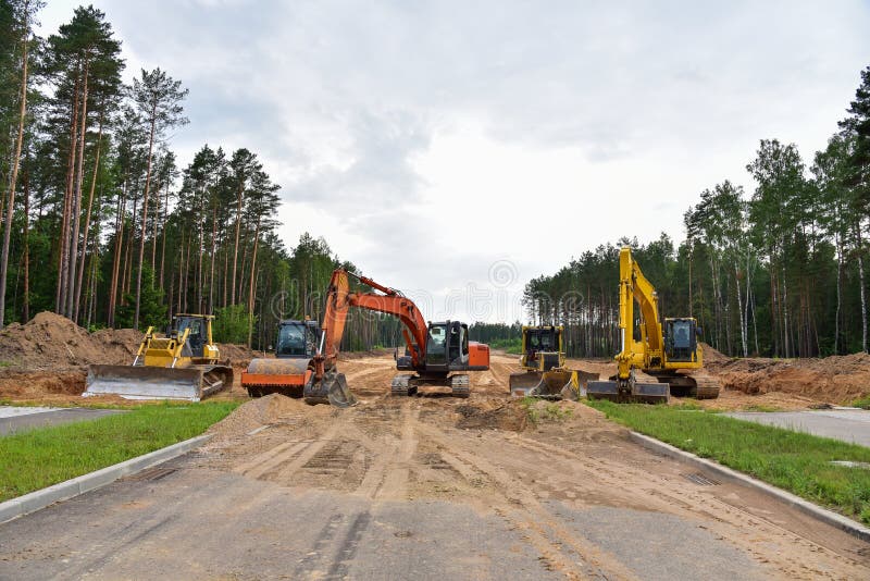 Экскаватор бульдозера и compactor почвы на дорожной работе. Тяжелые earthmoving строительная техника и оборудование в ходе земли стоковое фото rf