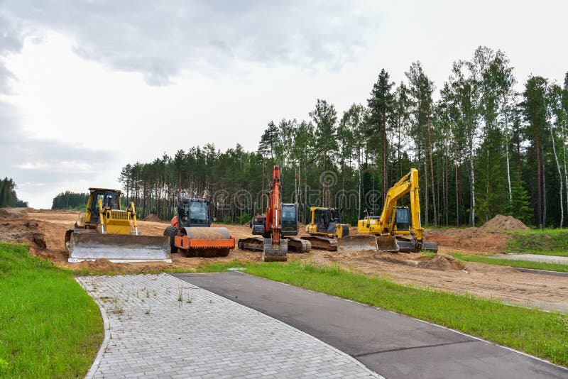 Экскаватор бульдозера и compactor почвы на дорожной работе. Тяжелые earthmoving строительная техника и оборудование в ходе земли стоковое фото rf