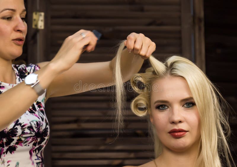 Элегантная белокурая женщина в салоне красоты Парикмахер coiffure в форме большой скручиваемости Стиль причёсок свадьбы концепции стоковые фотографии rf Элегантная белокурая женщина в салоне красоты Парикмахер coiffure в форме большой скручиваемости Стиль причёсок свадьбы концепции стоковые фотографии rf