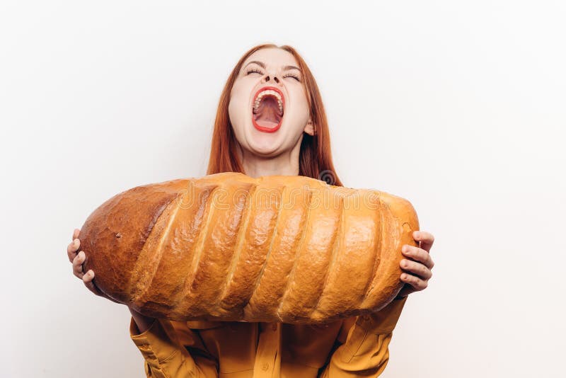 Эмоциональная женщина, открытие ее продукт муки голода рта широкий буханки хлеба стоковое фото