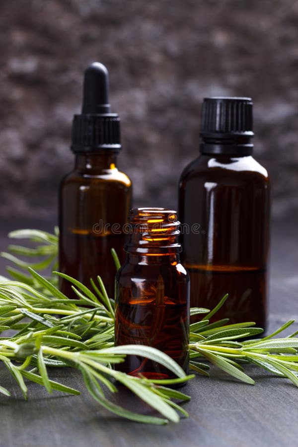 Rosemary essential oils, aromatherapy on dark wooden background. Selective focus. Rosemary essential oils, aromatherapy on dark wooden background. Selective focus