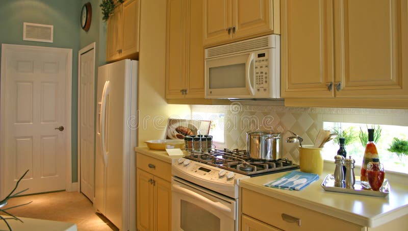 New efficient kitchen in pleasing colors of cream and blue with accessories in white. New efficient kitchen in pleasing colors of cream and blue with accessories in white
