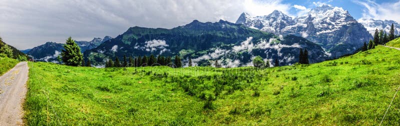 Эффектный панорамный взгляд Eiger, Monch, гор Jungfrau от Murren-Gimmelwald отстает, швейцарские горные вершины, Bernese Oberland стоковые изображения rf Эффектный панорамный взгляд Eiger, Monch, гор Jungfrau от Murren-Gimmelwald отстает, швейцарские горные вершины, Bernese Oberland стоковые изображения rf