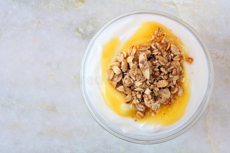 Югурт лимона с granola, надземным взглядом на белом мраморе стоковые изображения rf Югурт лимона с granola, надземным взглядом на белом мраморе стоковые изображения rf