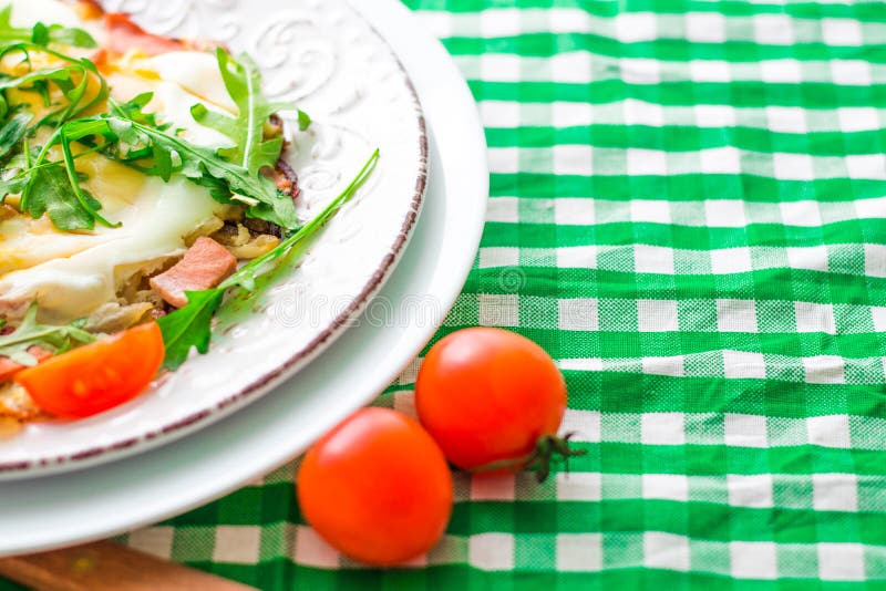 Яичницы с arugula и вишней томатов на белой плите и checkered ткани скопируйте космос стоковые изображения rf Яичницы с arugula и вишней томатов на белой плите и checkered ткани скопируйте космос стоковые изображения rf