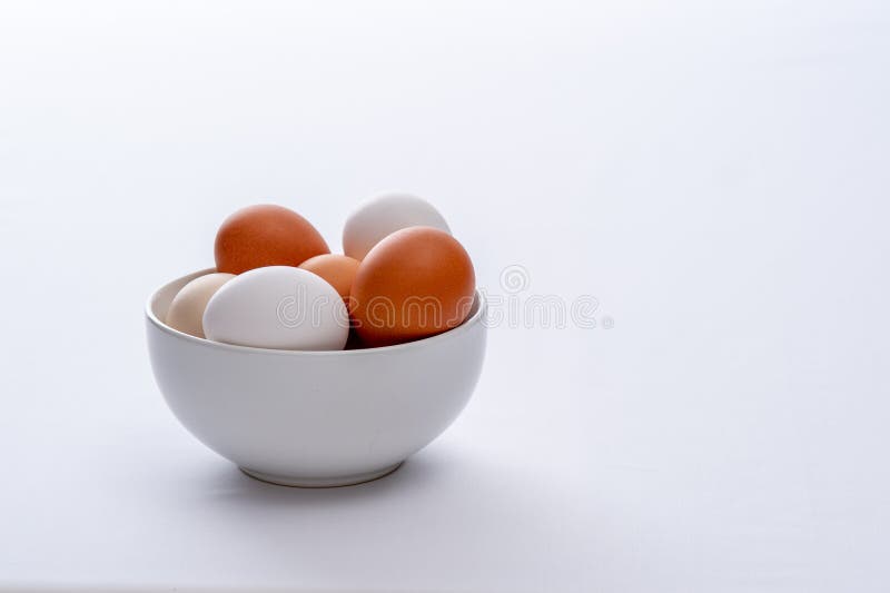 Close up of farm eggs in a white bowl with a white background. Close up of farm eggs in a white bowl with a white background