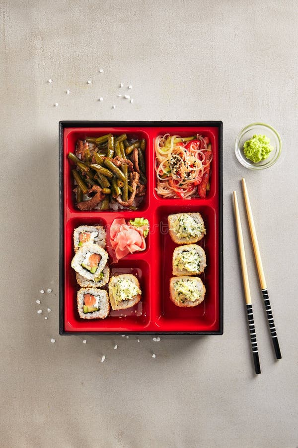 Японская коробка бенто с сушами Rolls, салатом и основным блюдом верхним v стоковые фотографии rf Японская коробка бенто с сушами Rolls, салатом и основным блюдом верхним v стоковые фотографии rf